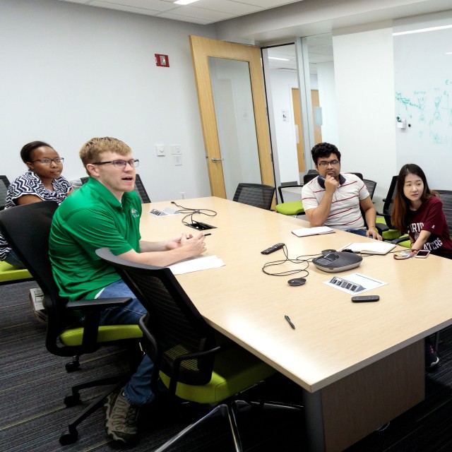 Esser-Kahn lab members Peter Deak, Flora Kimani, Saikat Manna, and Seong-Min Kim discuss data at a lab meeting