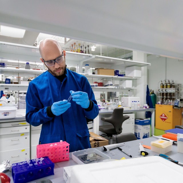 Esser-Kahn lab member Adam Weiss examines a sample at the lab bench