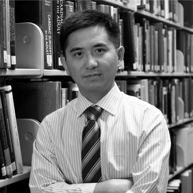 Black-and-white headshot of Jun Huang
